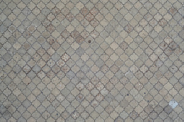 The texture of a rhythmic mosaic made of concrete tiles. Background image of a large area of old...