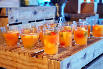 Various glass of orange juice with sliced fruit prepare for serving.
