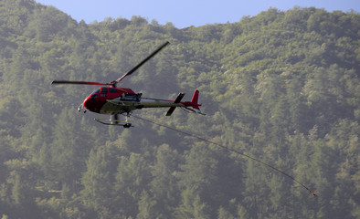 Obraz na płótnie Canvas helicopter carries cargo in the Alps at a construction site