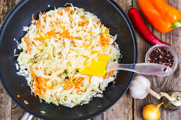 Chopped cabbage with carrots in frying pan