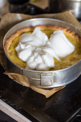 Cooking pie with rhubarb and meringues. Meringue is layed out on the pie.