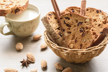 Traditional Italian biscotti Almond Cantuccini in a basket decorated with nuts on wooden table
