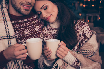 Close up cropped of adorable sweet cute friends embracing with hot chocolate, mulled-wine, smiling,...