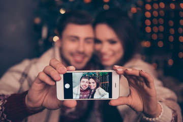 Cheerful husband and wife are photographers for their portrait. Not clear shot of them bonding hug embrace, lights on background, taking it on telephone, focus on smart pda, vague visual effects