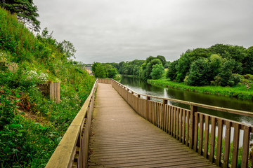 Pedestrian wooden walkway along river Don in Seaton park, Aberdeen, Scotland