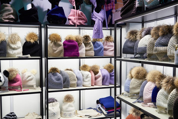 Winter colorful hats with fur pompom in shop