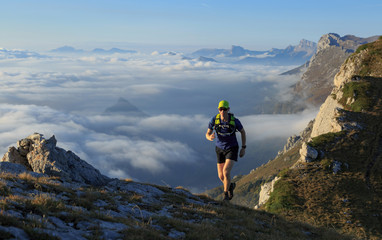 Athlete trailrunning in the mountains on a beautiful morning in the Vercors, France.