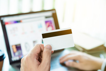 Close up of a man hands making online payment by credit card on laptop computer