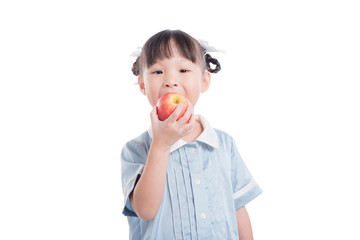 Little asian preschool girl wearing uniform and eating apple over white background