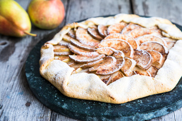 Pie with apples, pears and cinnamon on an old wooden background