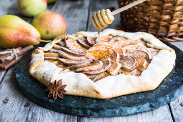Pie with apples, pears and cinnamon on an old wooden background