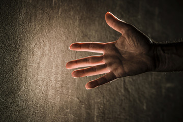Salvage from the tunnels under the ground, in the shafts, pit mines, caves and  collapsed buildings after the earthquake. Man stretches hand to the light so that someone may notice that he is alive. 