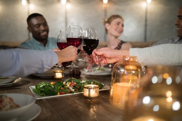 Friends toasting red wine in restaurant
