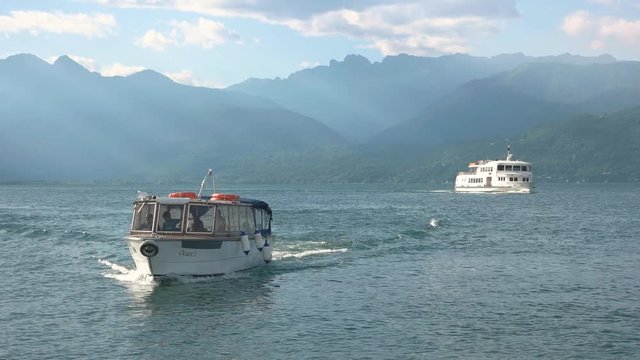 Tourist boats on lake Maggiore. Mountains, water and sky.