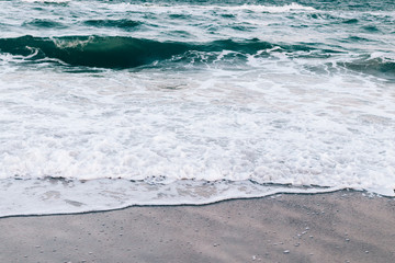 Sea waves rolled on a beach sand