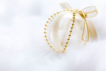 Gold Christmas baubles on white fur. Festive winter concept.