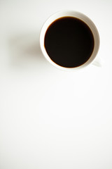 Over top view of coffee cup on white surface