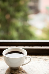 Coffee mug on a window sill. Morning coffee
