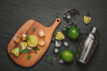 Mojito cocktail with lime and mint in glass on a grey stone background