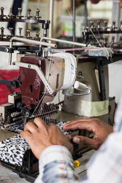 Person working on industrial smocking sewing machine in factory, Cape Town, South Africa