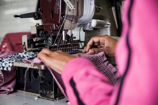 Seamstress working on industrial smocking sewing machine in factory, Cape Town, South Africa