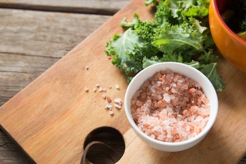 Fresh kale with rock salt on cutting board