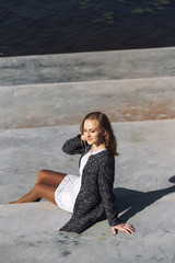 Portrait of a beautiful girl on the stairs near the sea