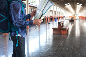 Young man tourist with backpack at the train station in town.