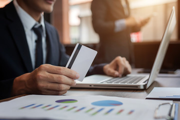 businessman holding credit card and using laptop computer. Online shopping concept