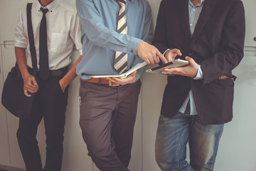 Businessman standing talking. Business people using a digital tablet