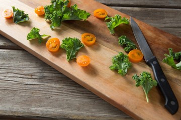 High angle view of kale and tomato slices on cutting board