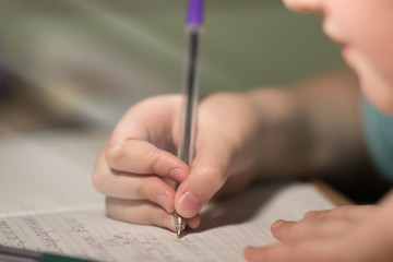 people, learning, education and school concept - close up of girl's hands writing math in notebook