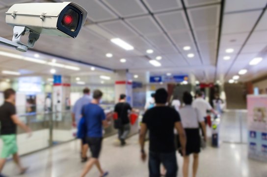 CCTV security indoor camera system operating with blurred image of people walking at train station, transportation, surveillance security, safety technology concept