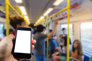 hand using smart phone isolated blank screen with blurred image of people in subway at train station, people lifestyle, transportation, technology, internet, network connection, social media concept