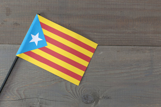 A flag of Catalonia on a wooden background. 