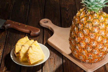 slices of a pineapple on dark wooden background