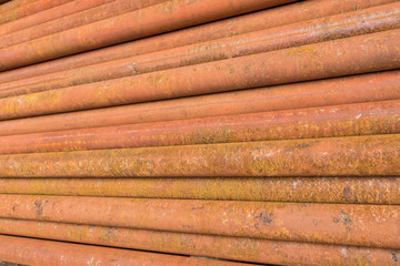 rusty metal tubes and pipes for construction and industrial use laying on heap