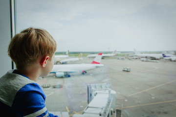 Fototapeta na wymiar little boy looking at planes travel in airport