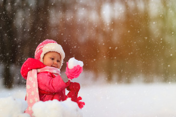 cute little girl play with winter snow