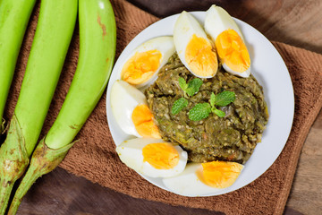 Northern Thai food (Tum Makeua Yao).Grilled green eggplant pounding with chili and spices and eating with boiled egg
