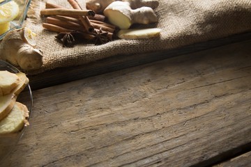 Ginger with cinnamons on burlap over table