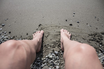 Human feet in the sand on a beach. - 175476949