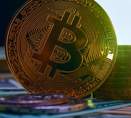 Fototapeta na wymiar golden bitcoin on a dark background with a column of coins.