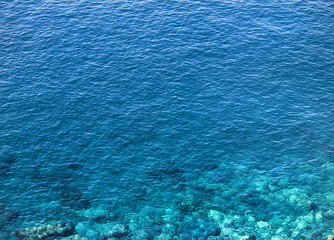 Crystal clear blue ocean water. Close up shot with very nice lights and coral showing beneath the surface. Mediterranean environment. - 175477112