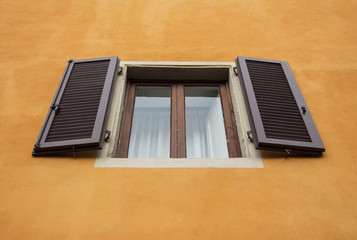 Vintage window shutter/frames in an old stone house. Yellowish nuance/tone and brown-colored wooden windows in an old country house. - 175477149