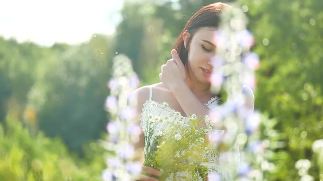 happy girl in a field with flowers in nature. girl in a field smiling woman holding a outdoor bouquet of flowers