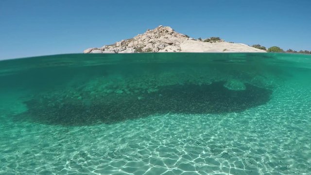 The bottom of an exotic beach on half underwater view