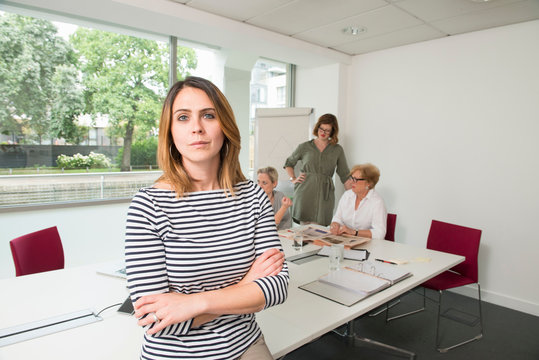 Businesswoman, colleagues meeting in background