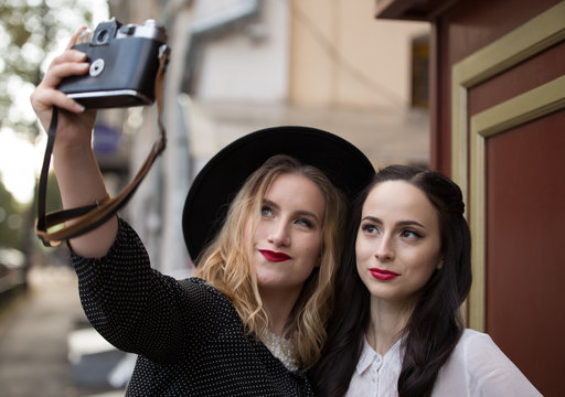 Two young woman making selfie on street
