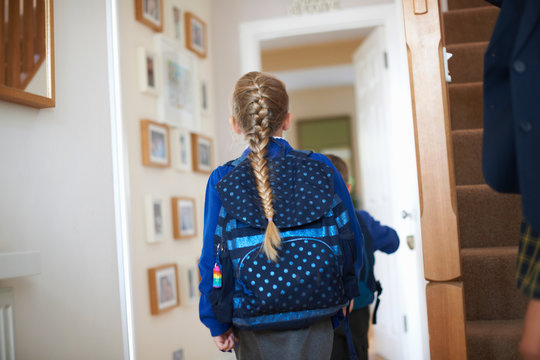 Rear view of schoolgirl in uniform in hallway - Powered by Adobe